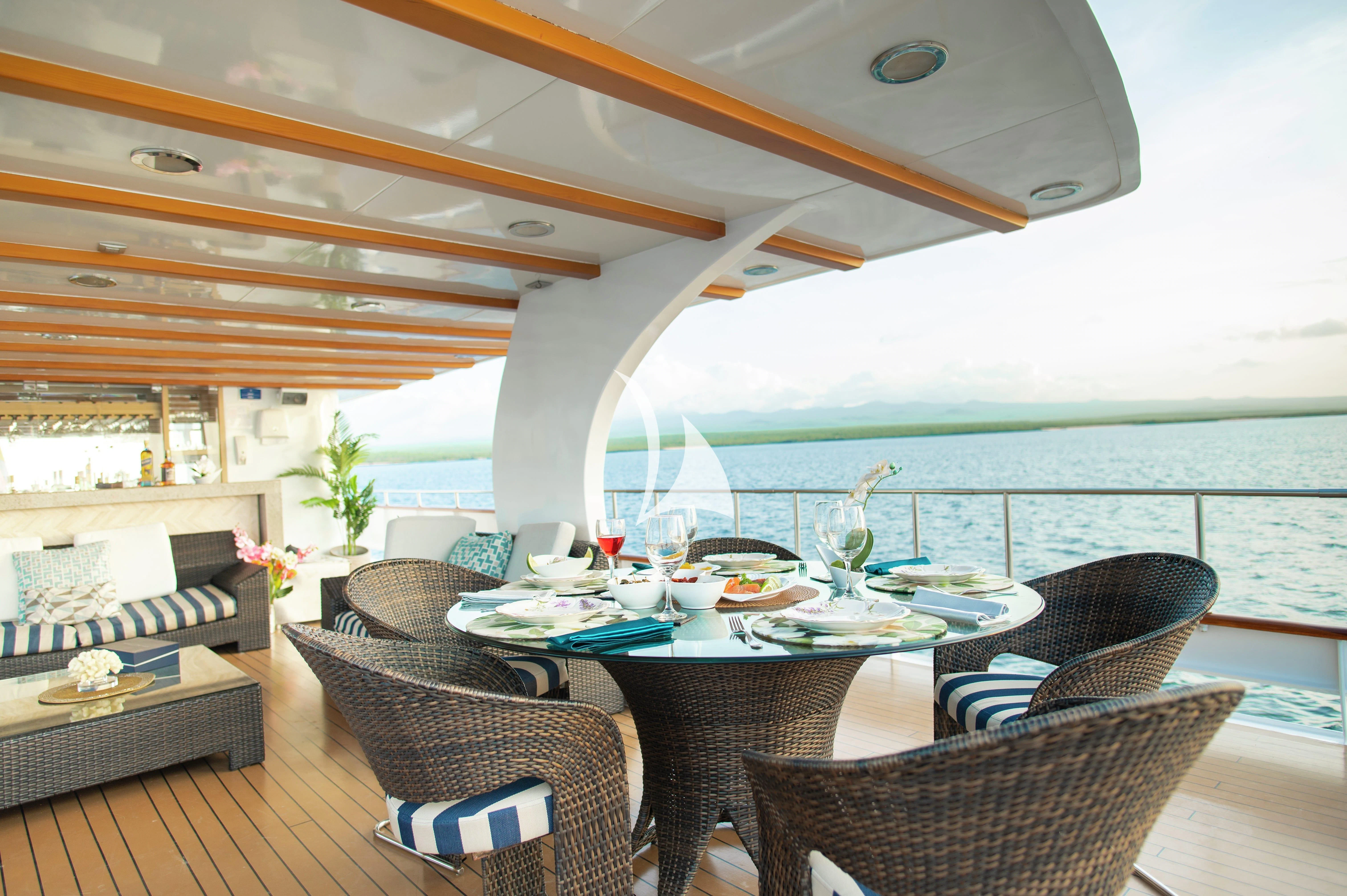 a table and chairs on a deck aboard GALAPAGOS EXPLORER Yacht for Sale