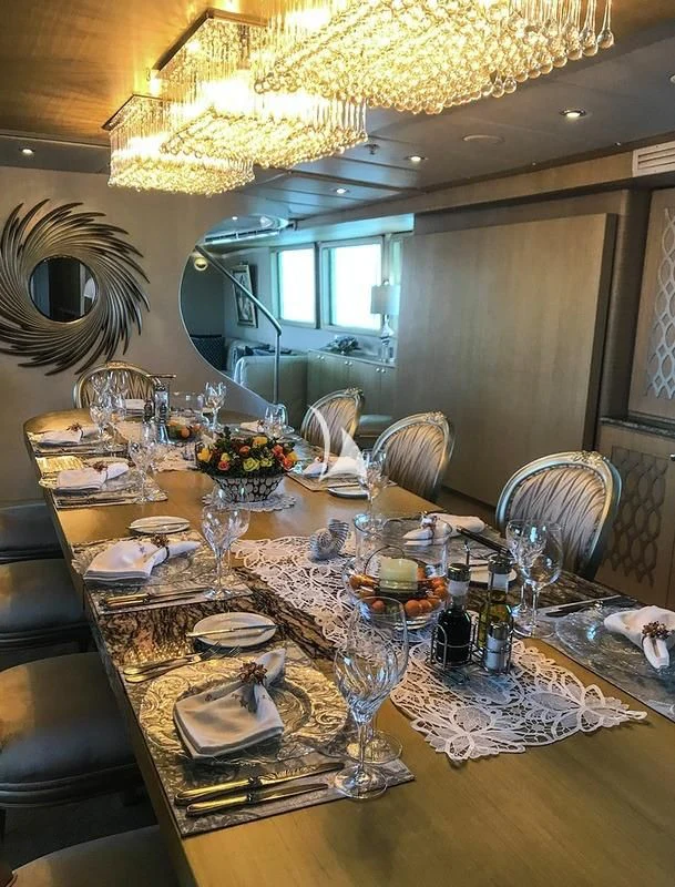 a dining table with plates and glasses aboard GALAPAGOS EXPLORER Yacht for Sale