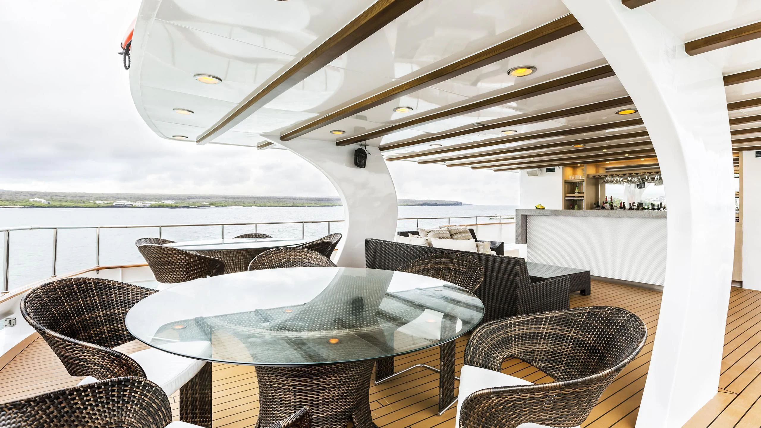 a lounge chair on a deck overlooking a body of water aboard GALAPAGOS EXPLORER Yacht for Sale