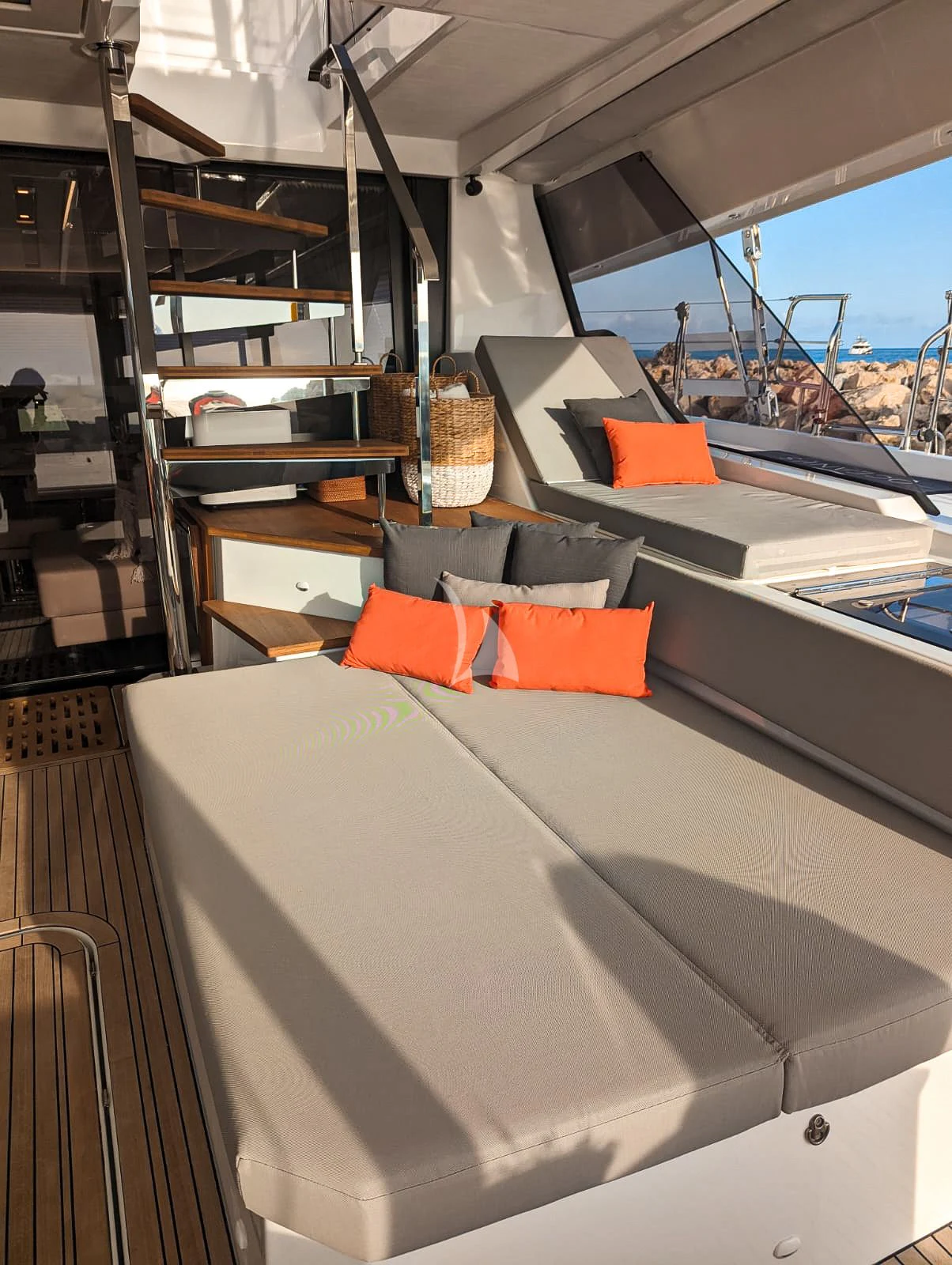 a room with a large white table and orange pillows aboard OCEANUS Yacht for Sale