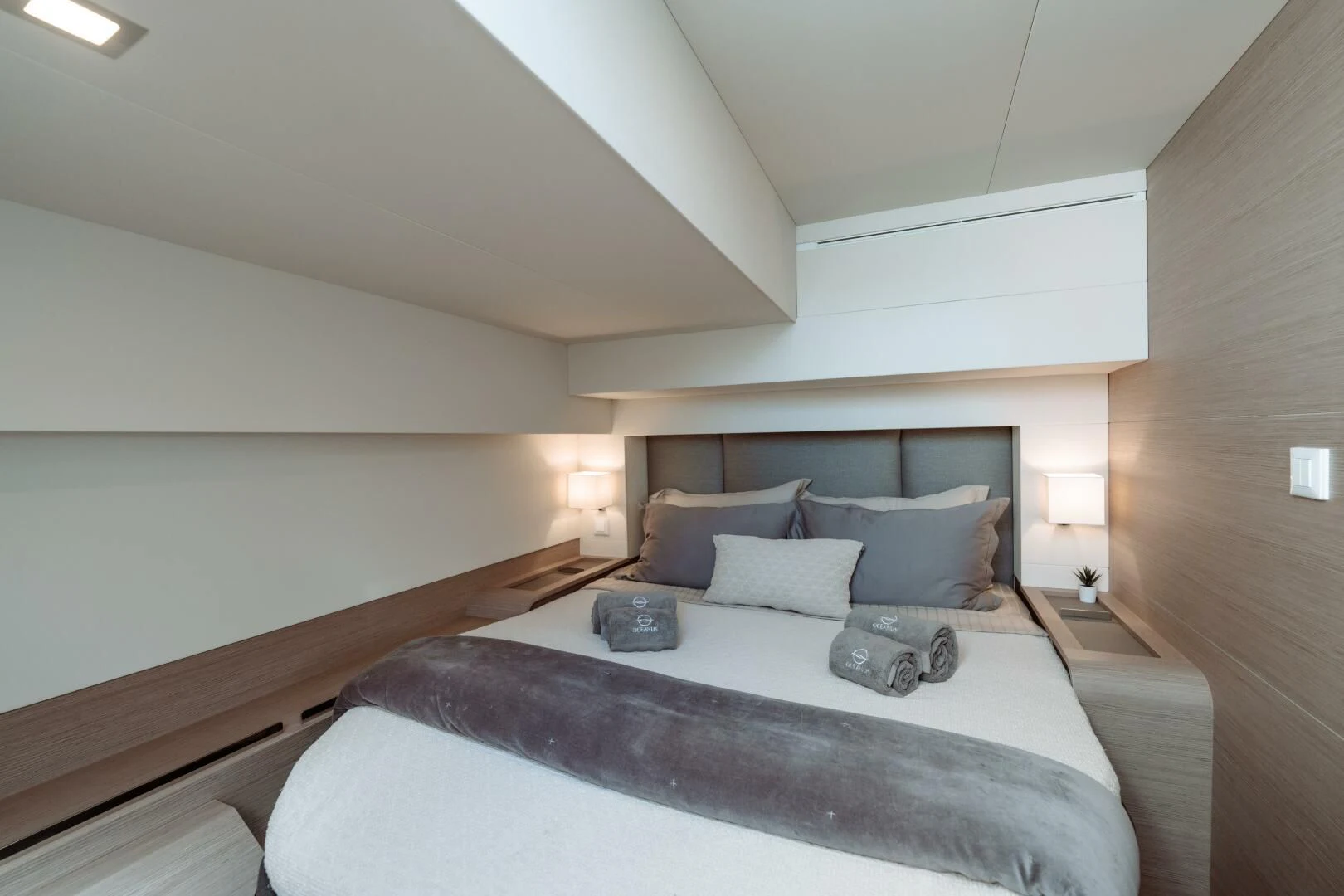 a bed with a white bed spread aboard OCEANUS Yacht for Sale
