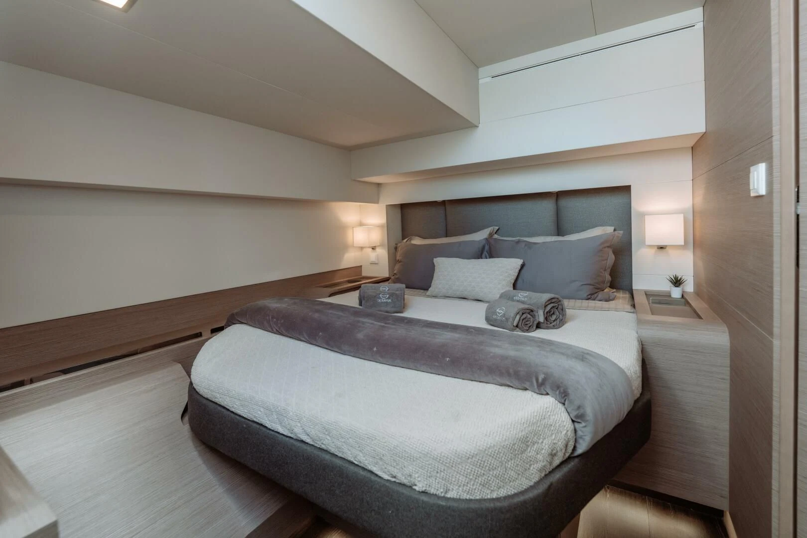 a bed with a white comforter aboard OCEANUS Yacht for Sale