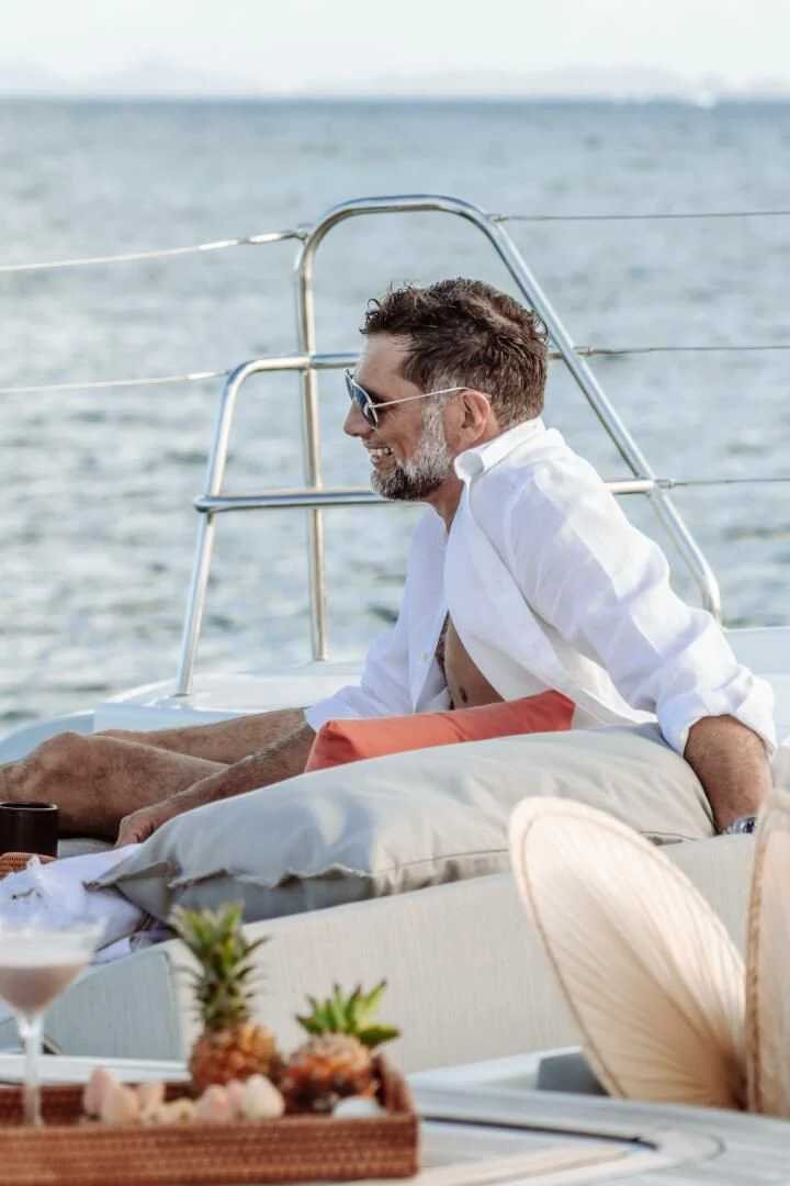 a man sitting on a boat aboard OCEANUS Yacht for Sale