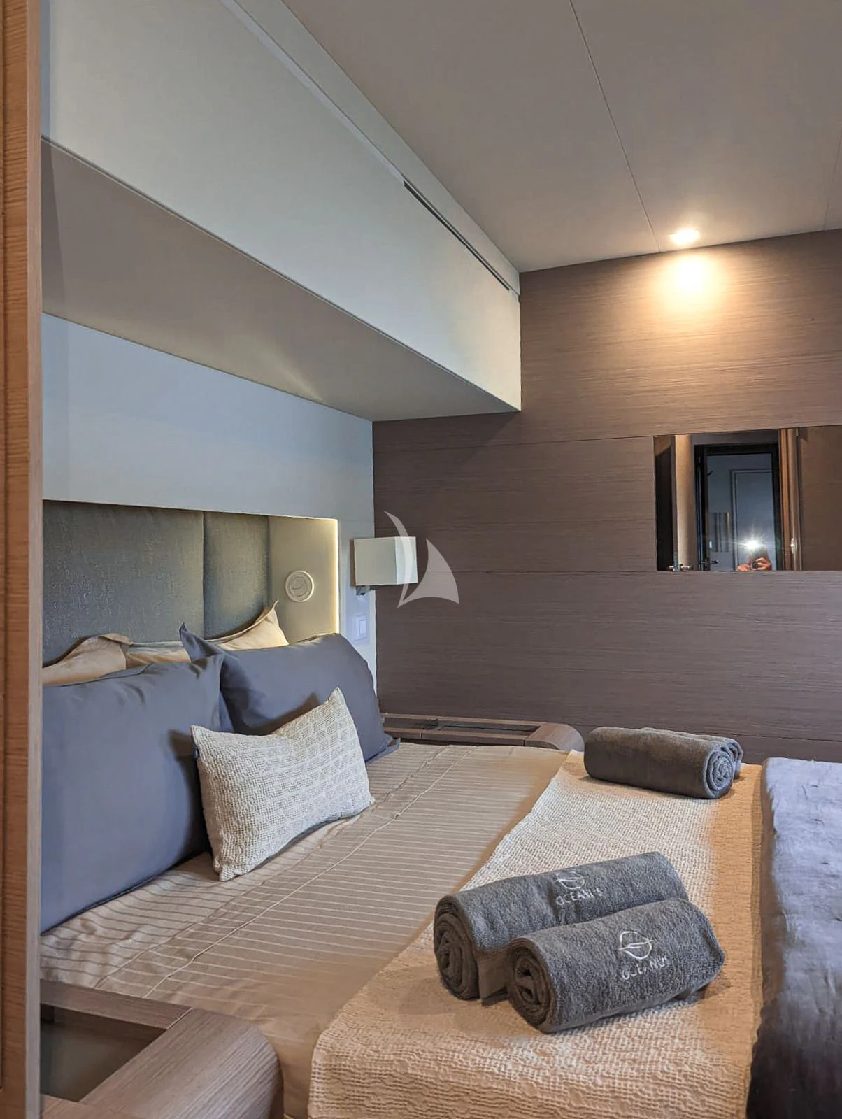 a bed with a blue pillow aboard OCEANUS Yacht for Sale
