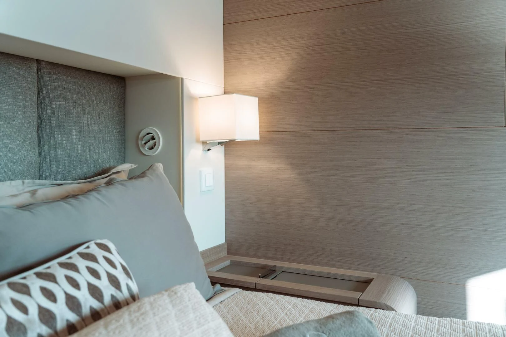 a bed with a wooden headboard aboard OCEANUS Yacht for Sale