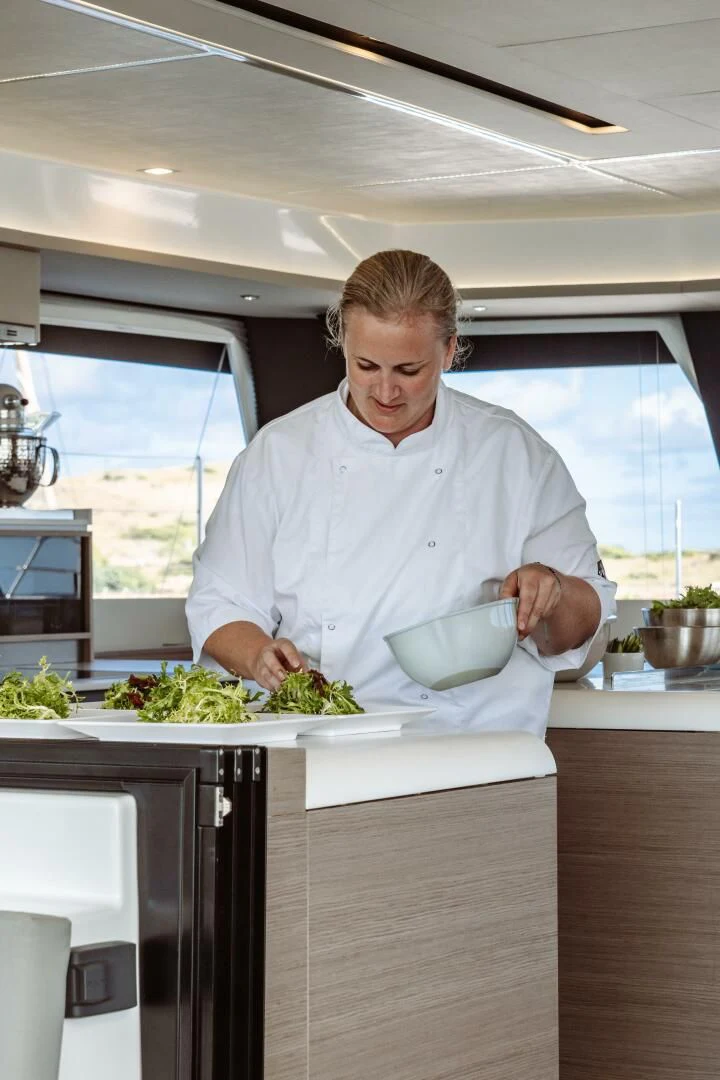 a man in a kitchen preparing a meal aboard OCEANUS Yacht for Sale
