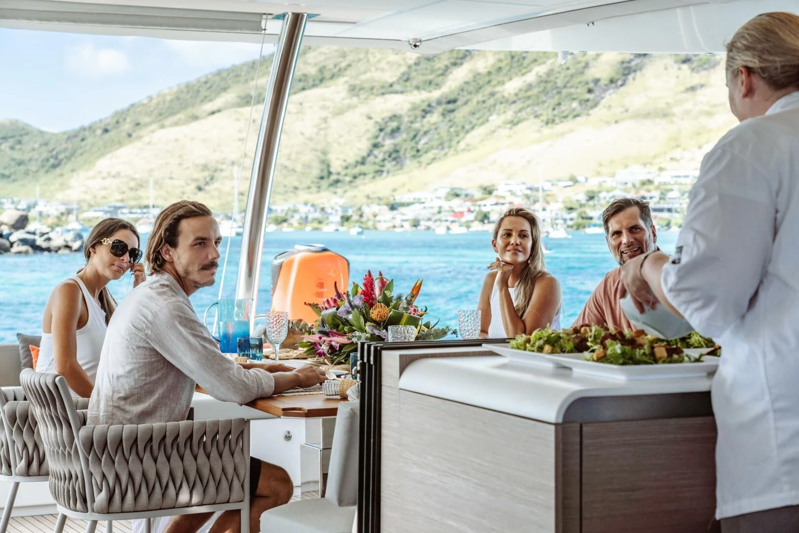 a group of people sitting at a table with food on it aboard OCEANUS Yacht for Sale
