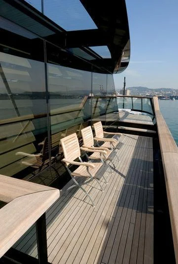 a deck with chairs and tables on it aboard MAIN Yacht for Sale