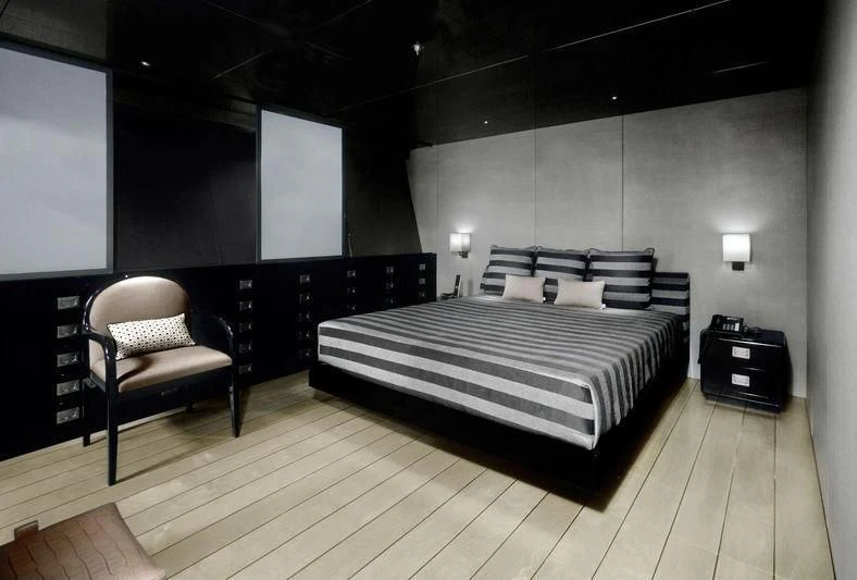 a bedroom with a bed and a chair aboard MAIN Yacht for Sale