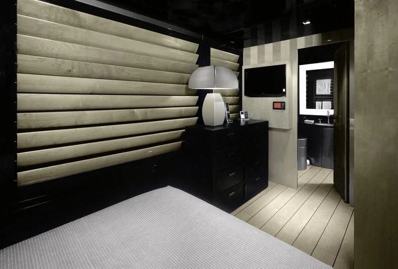 a room with a bed and a television aboard MAIN Yacht for Sale