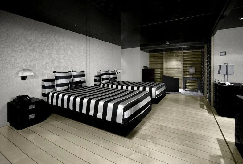 a large bedroom with a wood floor aboard MAIN Yacht for Sale