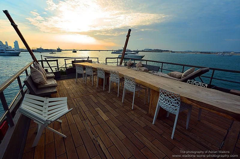 a deck with chairs and tables on it aboard MOJO Yacht for Sale