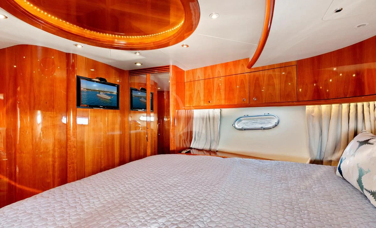 a room with a bed and a television aboard PRIVEE Yacht for Sale