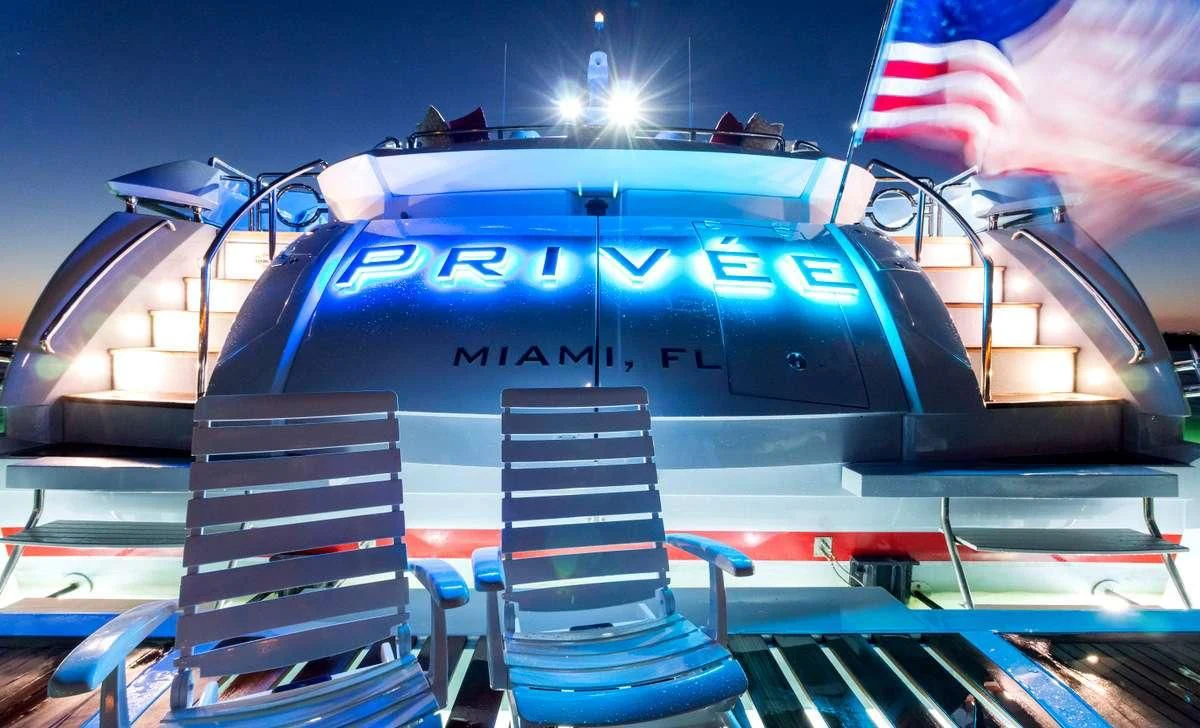 a blue and silver race car with a flag on top aboard PRIVEE Yacht for Sale