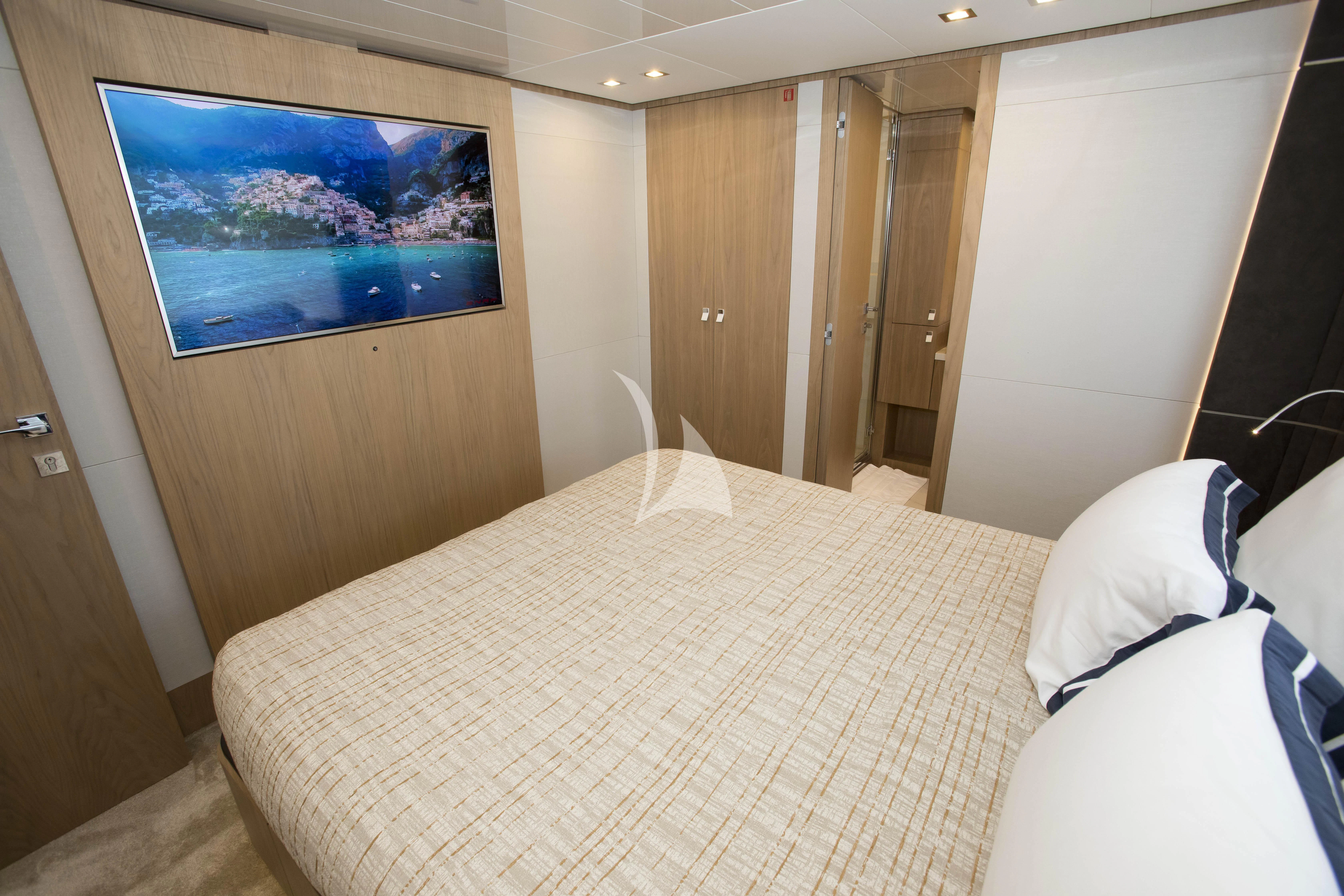 a hotel room with a bed and a television aboard DAMARI Yacht for Charter