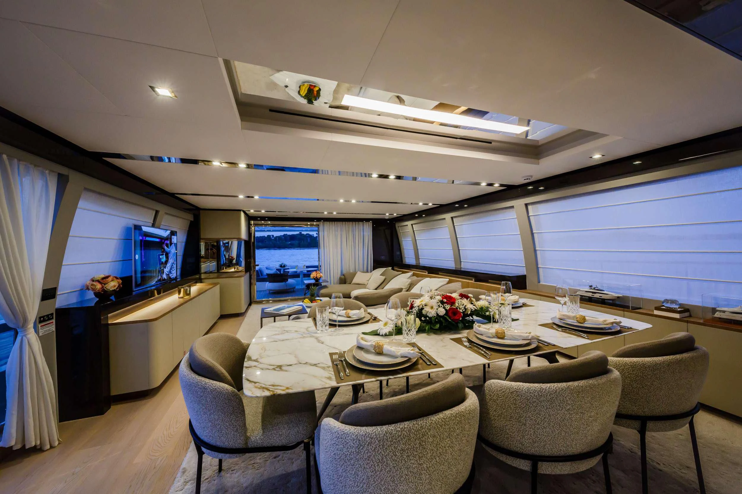 a room with a table chairs and a tv aboard DAMARI Yacht for Charter