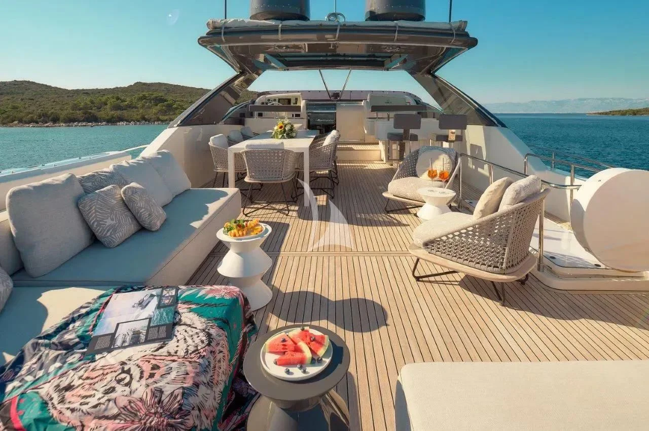 a deck with a large bed and a table on it aboard DAMARI Yacht for Charter