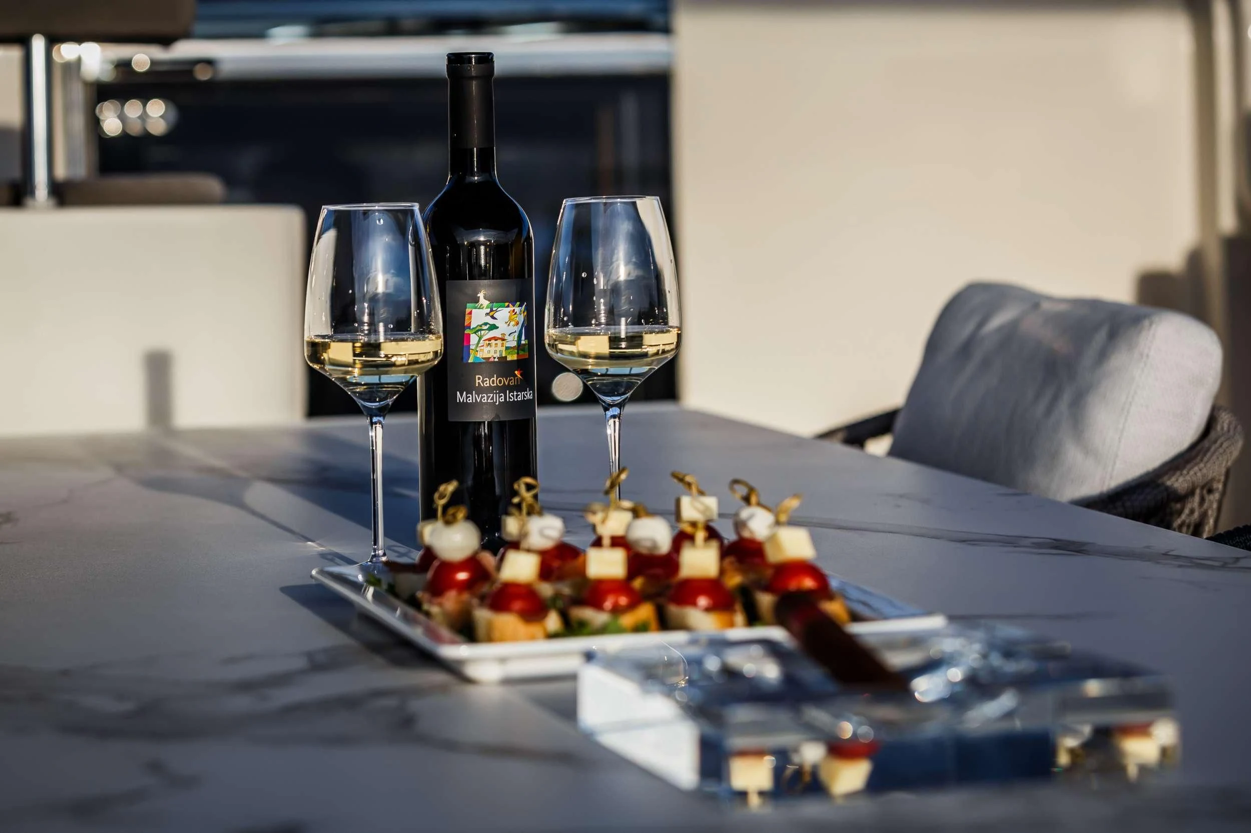 a bottle of wine and a tray of food on a table aboard DAMARI Yacht for Charter