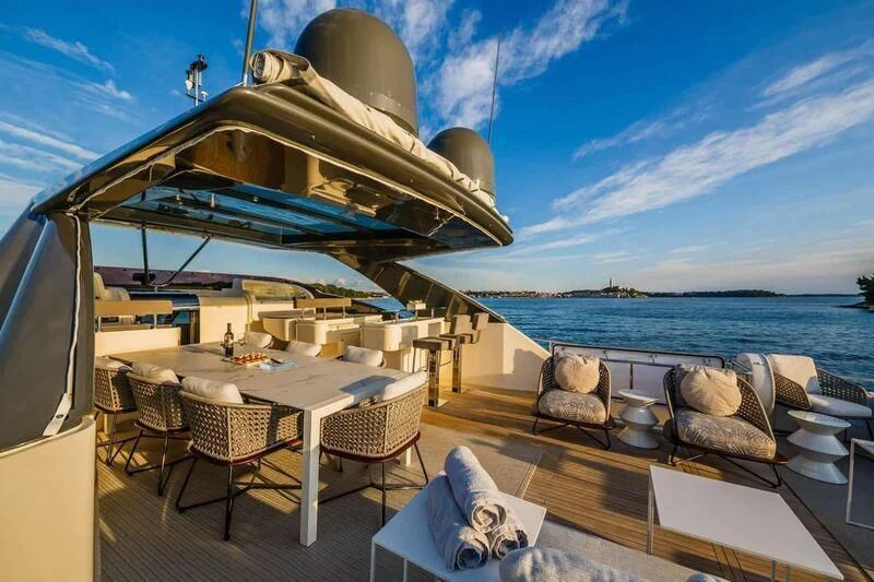 a large building with a large deck and chairs on the deck aboard DAMARI Yacht for Charter