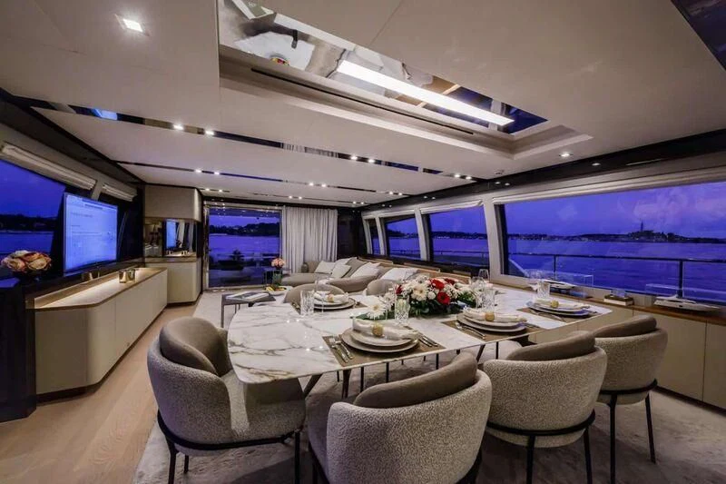 a room with a table chairs and a tv aboard DAMARI Yacht for Charter