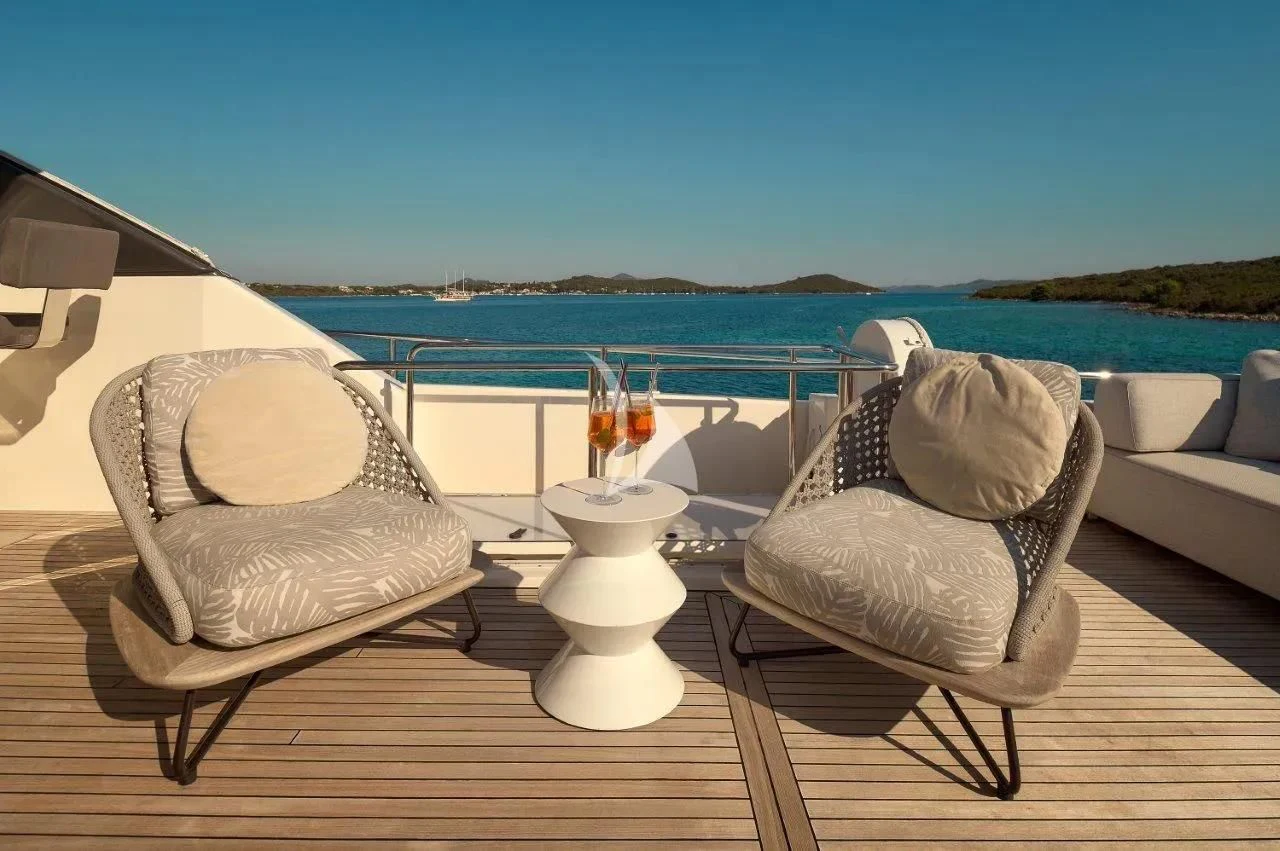 a couple of chairs on a deck overlooking a body of water aboard DAMARI Yacht for Charter