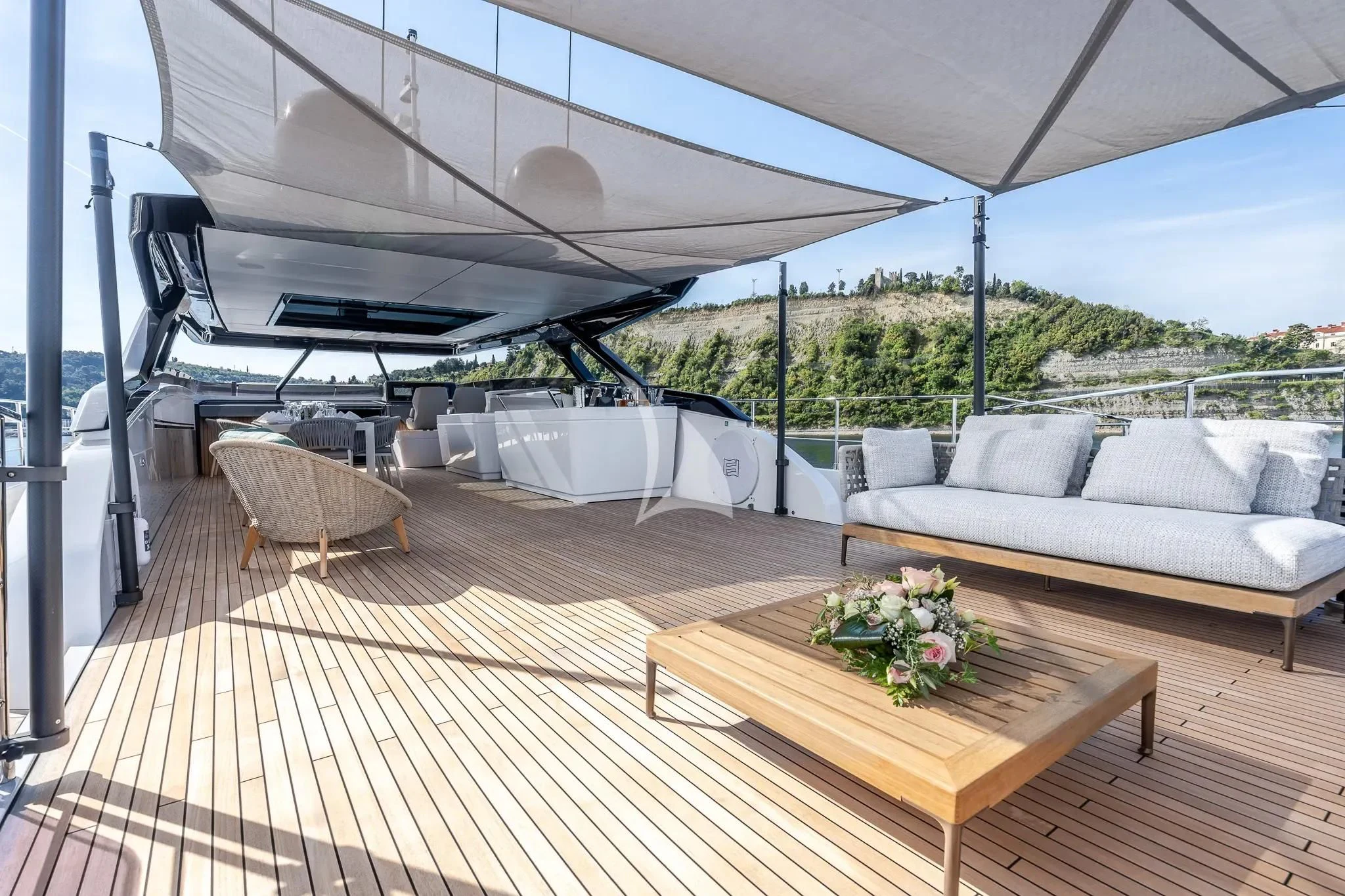 a deck with a table and chairs aboard DAMARI Yacht for Charter