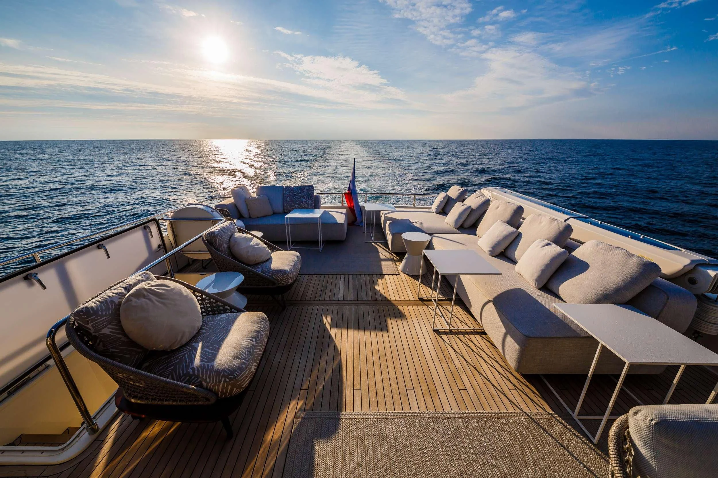 a deck with chairs and a large body of water in the background aboard DAMARI Yacht for Charter