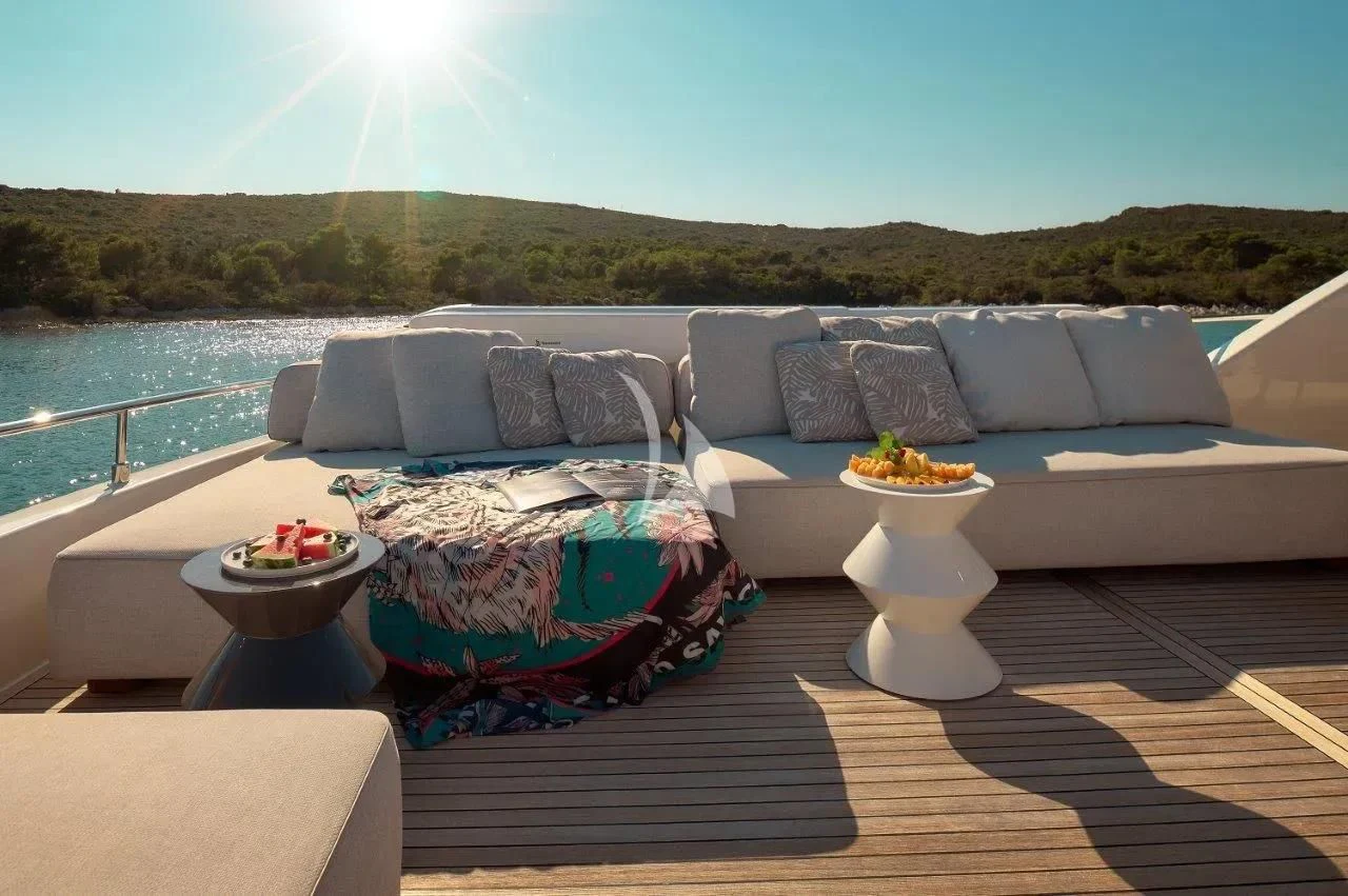 a deck with a couch and a pool and a large body of water aboard DAMARI Yacht for Charter