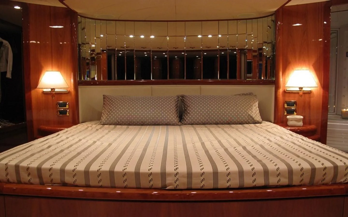 a bed with a white sheet and a lamp on it aboard BEIJA FLORE Yacht for Charter