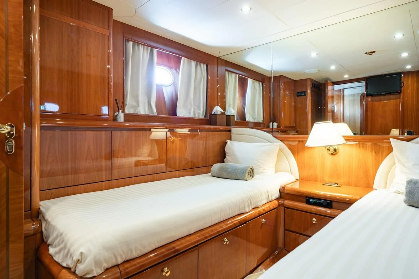 a room with a bed and a wood cabinet aboard BEIJA FLORE Yacht for Charter