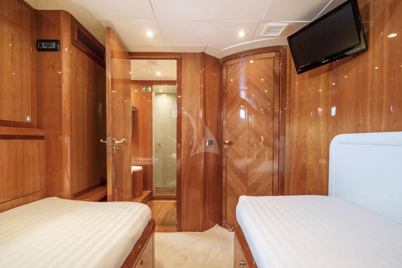 a room with a bed and a television aboard BEIJA FLORE Yacht for Charter