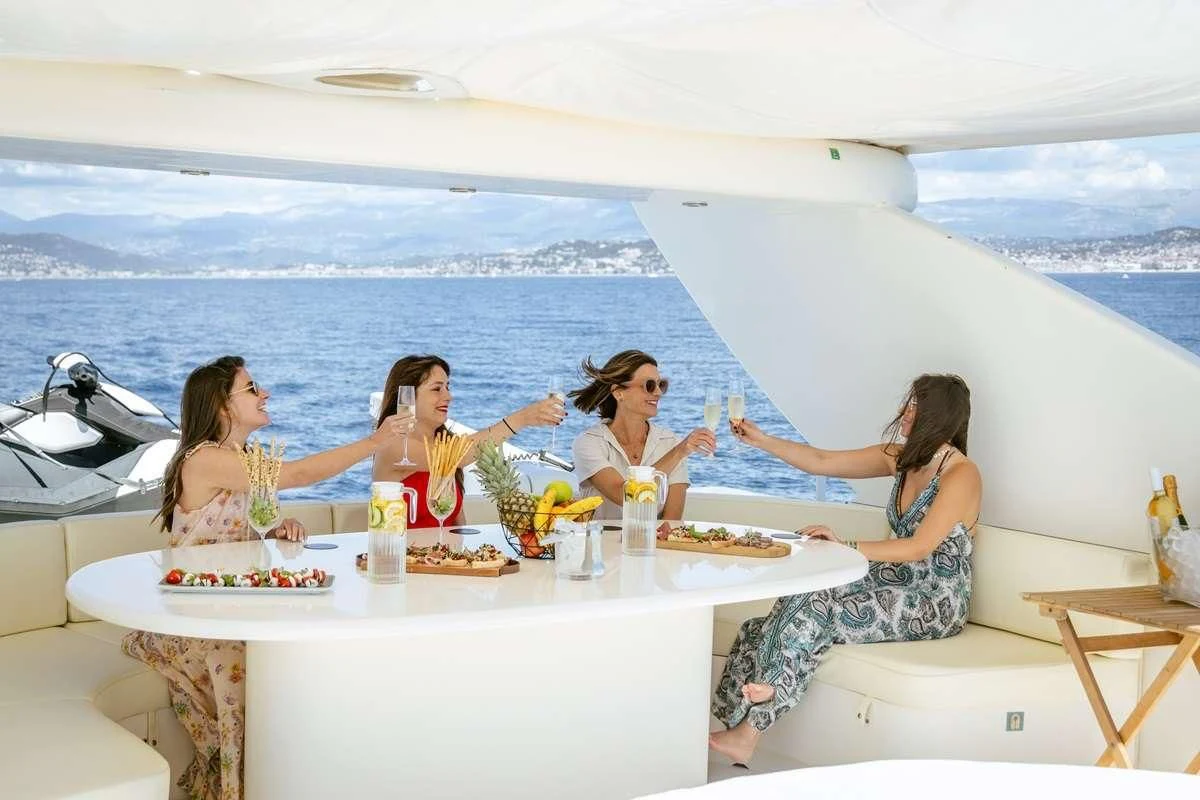 a group of women sitting at a table with food on it aboard BEIJA FLORE Yacht for Charter