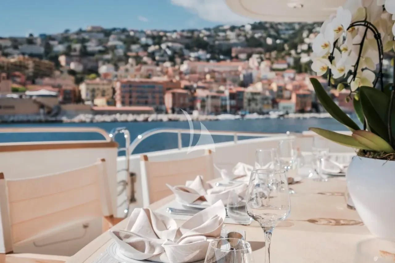 a table with chairs and a view of a city aboard BEIJA FLORE Yacht for Charter