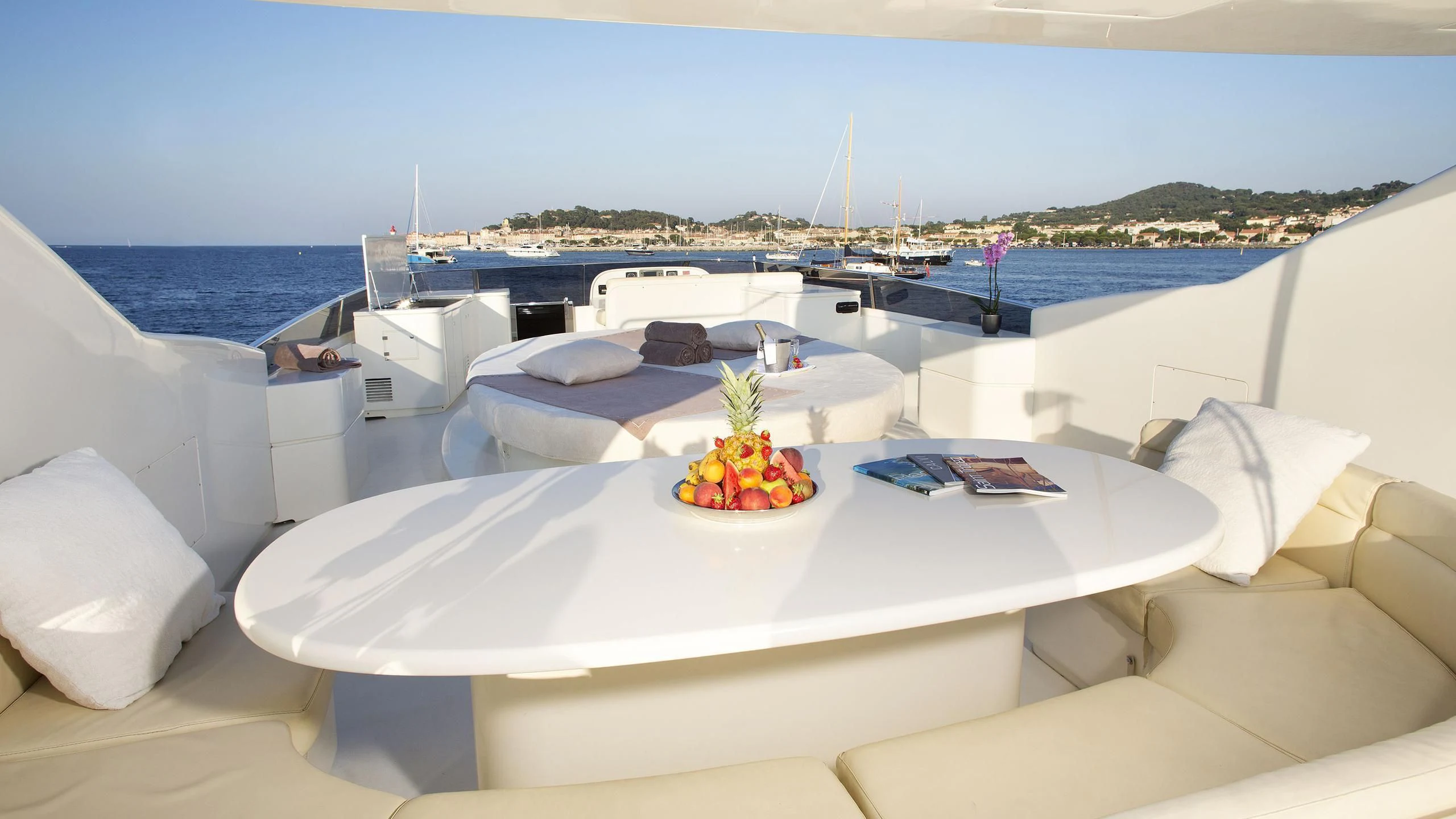 a room with a large white table and a large white bed with a white tablecloth with fruit aboard BEIJA FLORE Yacht for Charter