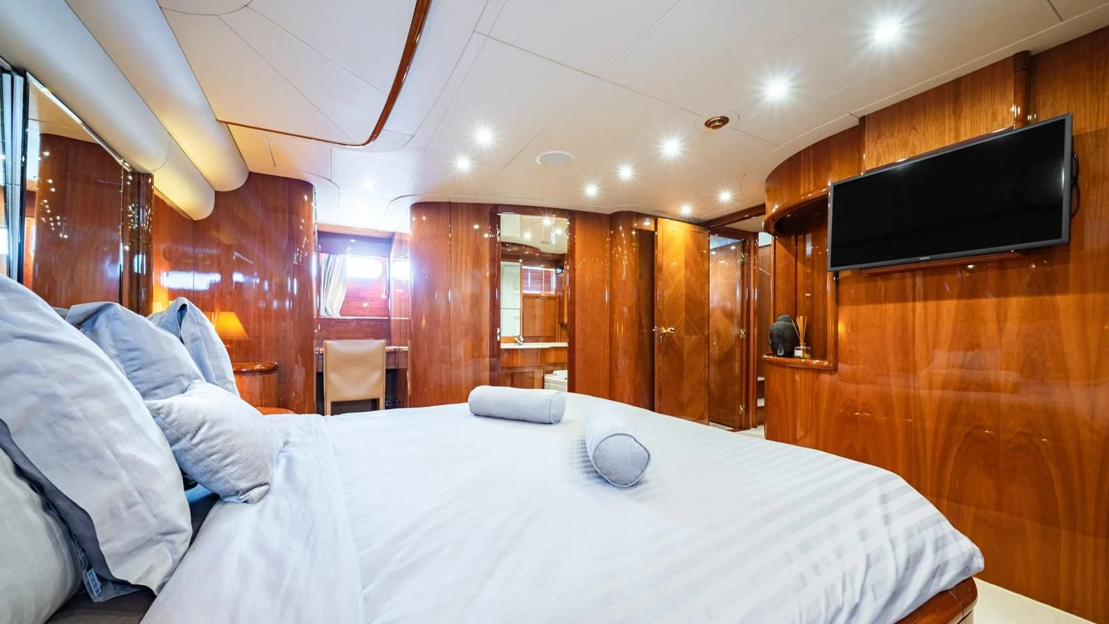 a bed with a white sheet and a television on it aboard BEIJA FLORE Yacht for Charter