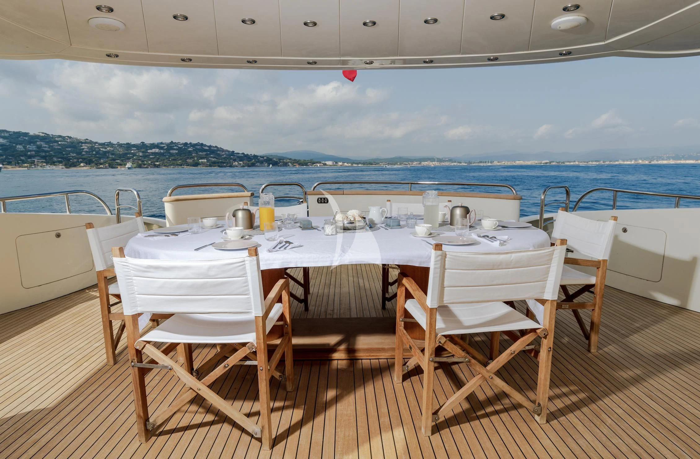 a table set for a meal on a deck overlooking the ocean aboard BEIJA FLORE Yacht for Charter