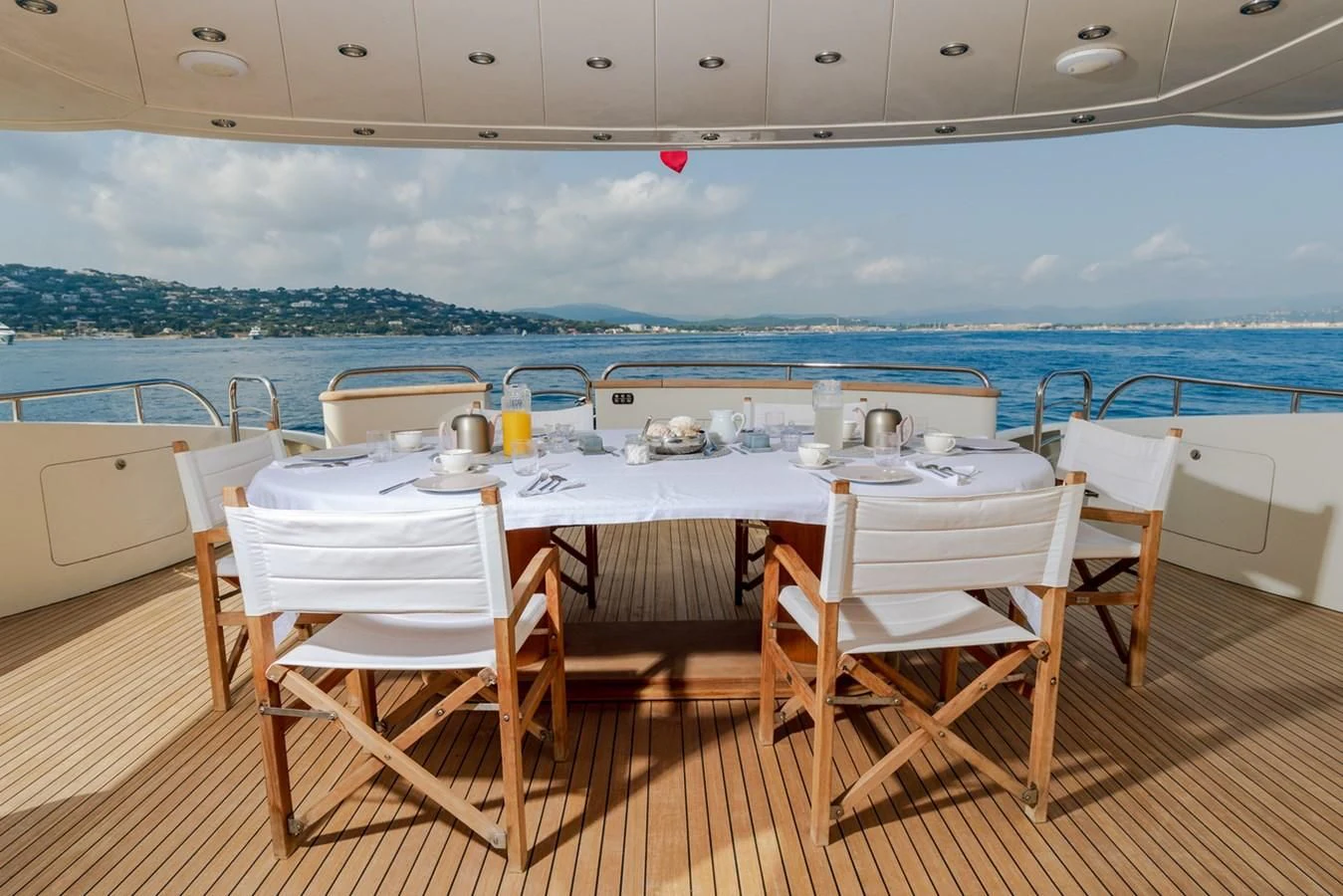 a table set for a meal on a deck overlooking the ocean aboard BEIJA FLORE Yacht for Charter