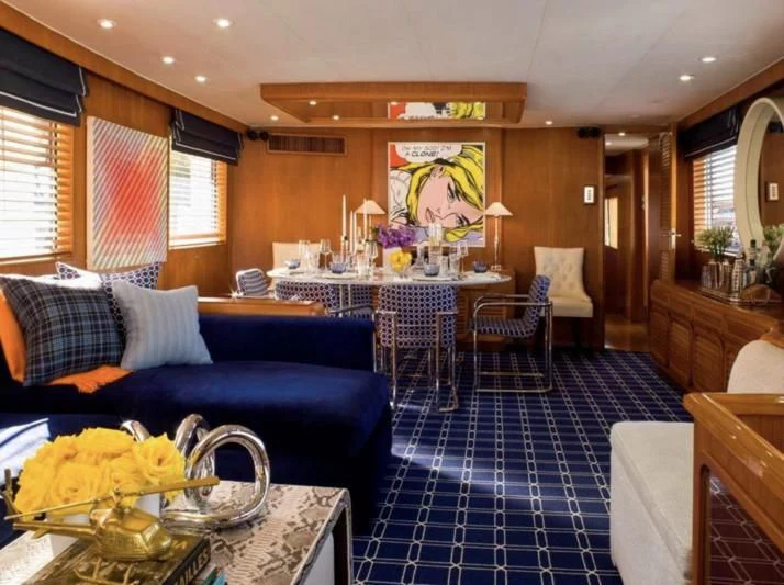 a living room with a blue couch and a table with flowers aboard GOING GALT Yacht for Sale