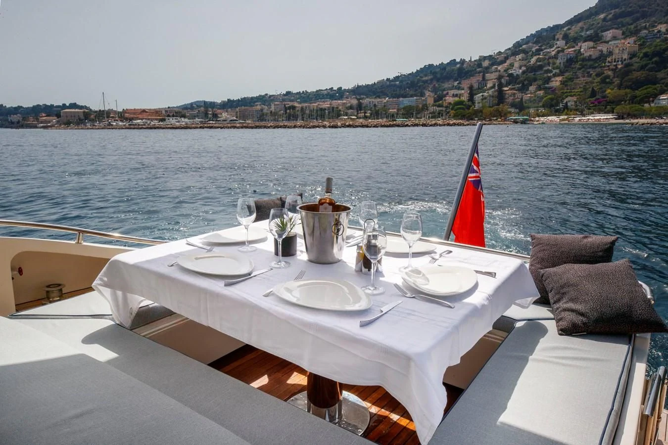 a table with plates and glasses on it by a body of water aboard KOKAB Yacht for Charter
