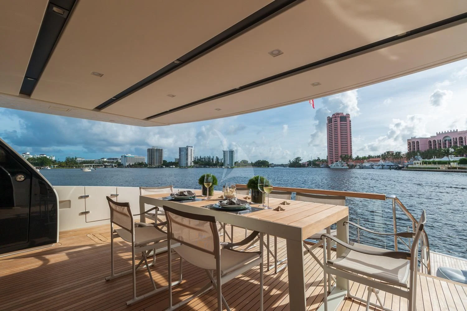 a table and chairs on a deck overlooking a city aboard SWEET VIRGINIA Yacht for Sale