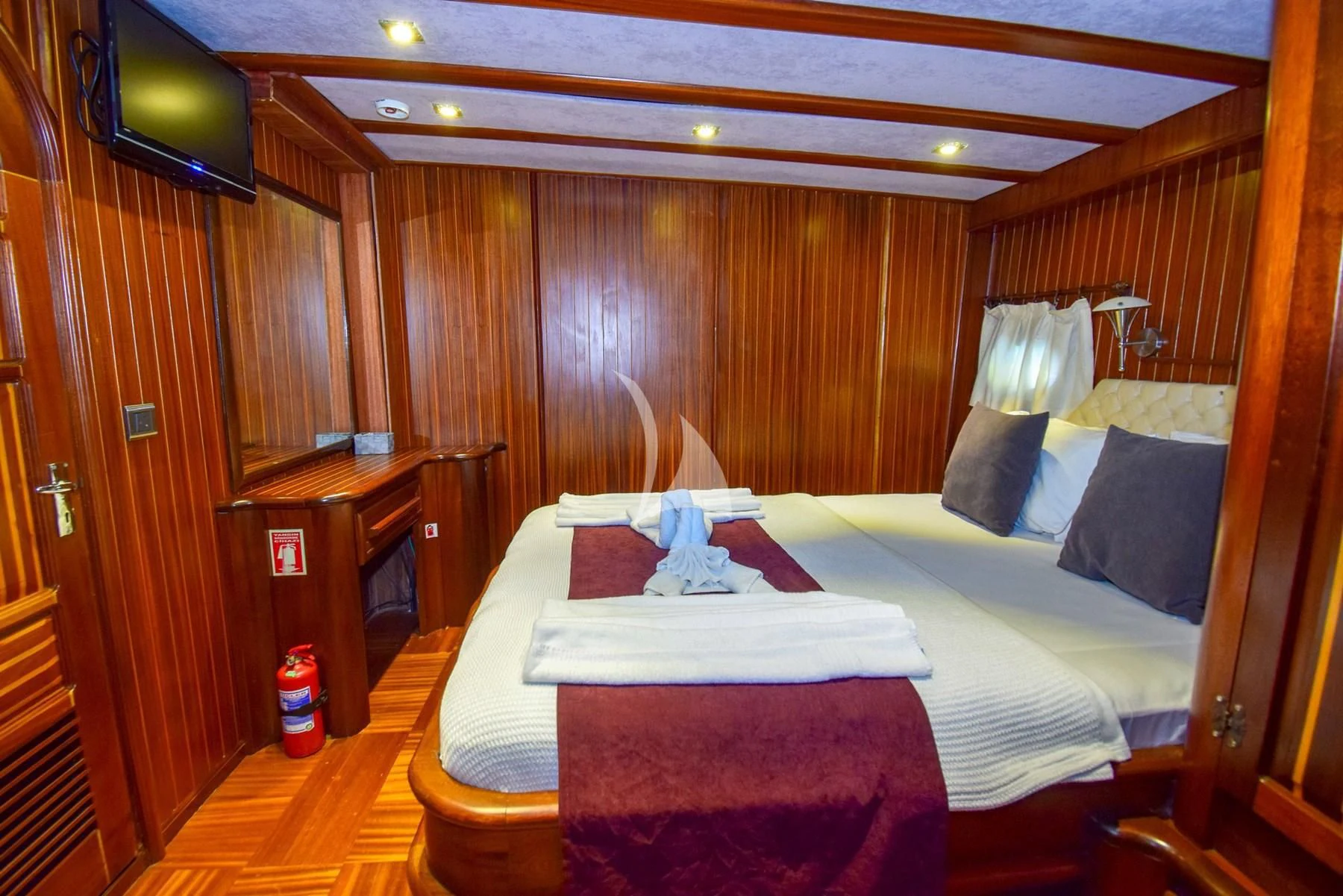 a room with a bed and a television aboard UGUR Yacht for Sale