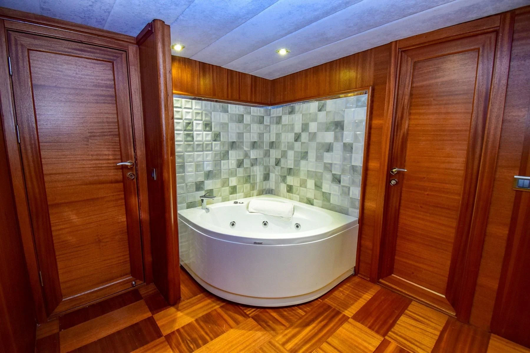a bathroom with a bathtub and wooden cabinets aboard UGUR Yacht for Sale