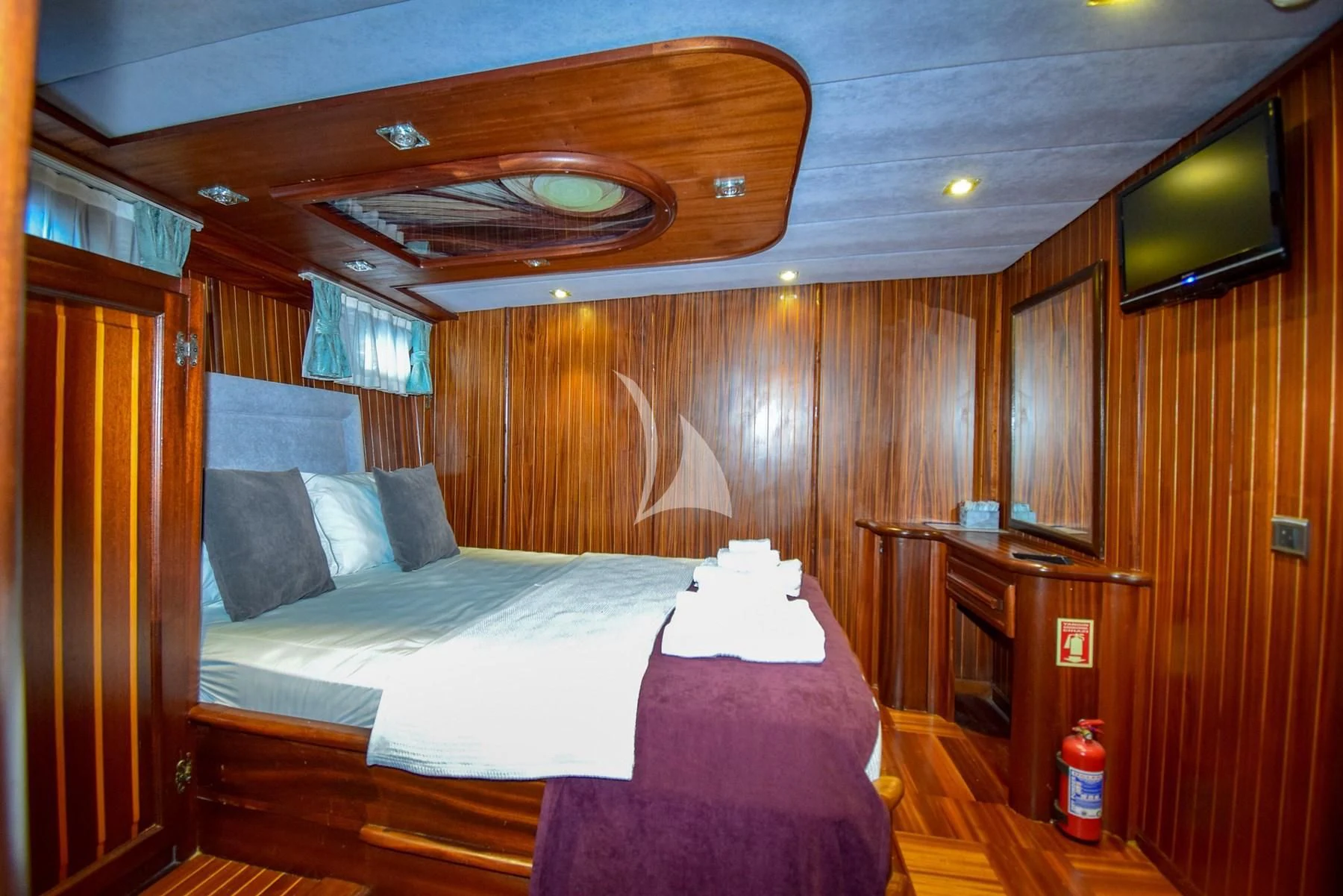 a room with a bed and a television aboard UGUR Yacht for Sale