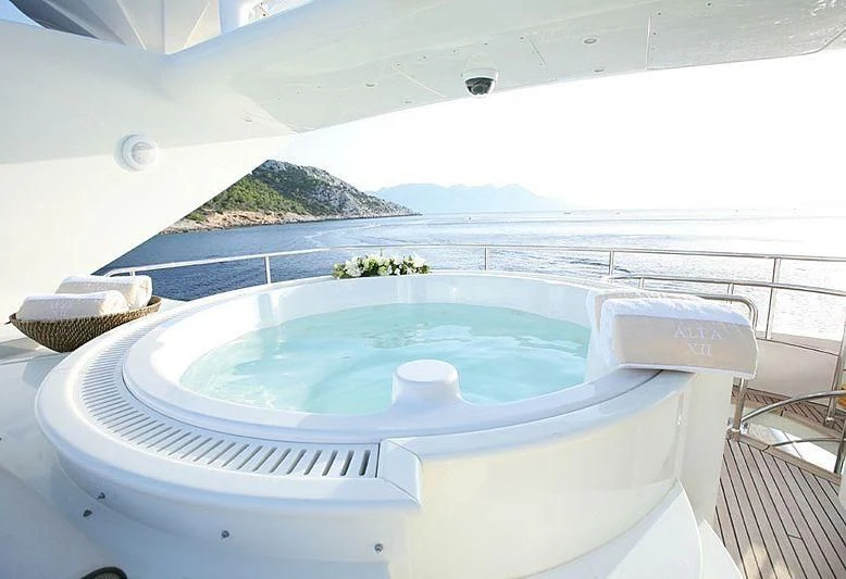 a swimming pool with a view of the mountains and water aboard ALFA XII Yacht for Sale