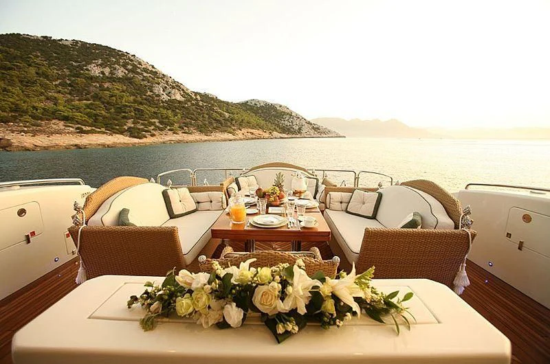 a table with chairs and a view of the ocean aboard ALFA XII Yacht for Sale
