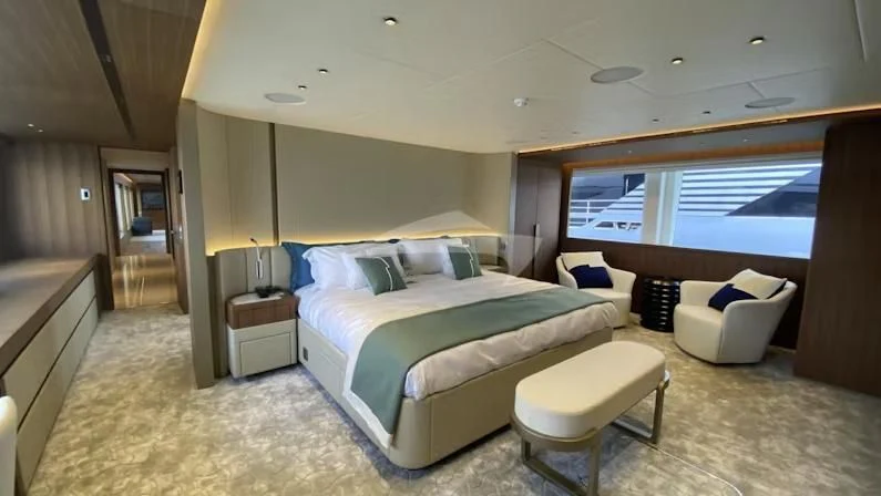 a large bedroom with a bed and a desk aboard RISING DAWN Yacht for Sale