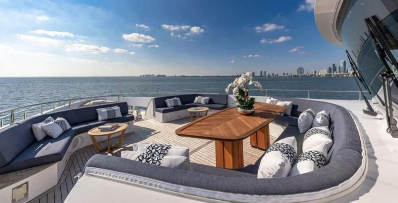 a large bed on a balcony overlooking a body of water aboard RISING DAWN Yacht for Sale