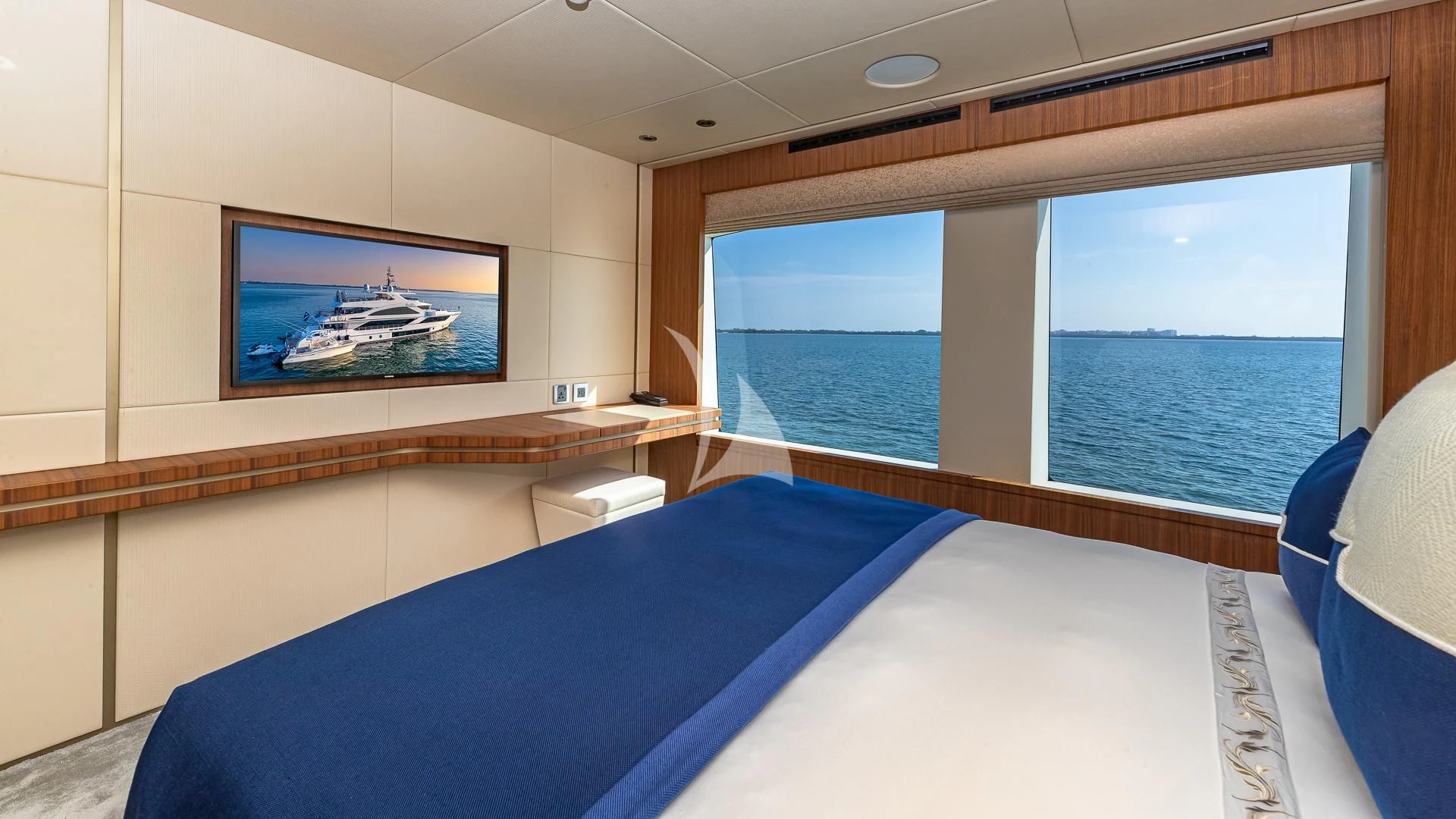 a room with a bed and a television on the wall aboard RISING DAWN Yacht for Sale
