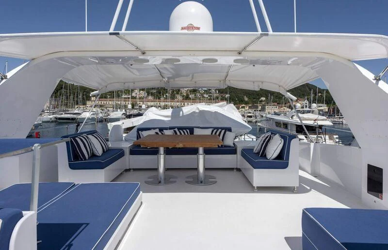 a lounge area with a large building in the background aboard VISOTTA Yacht for Sale