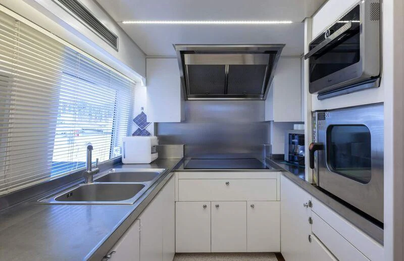 a kitchen with white cabinets aboard VISOTTA Yacht for Sale